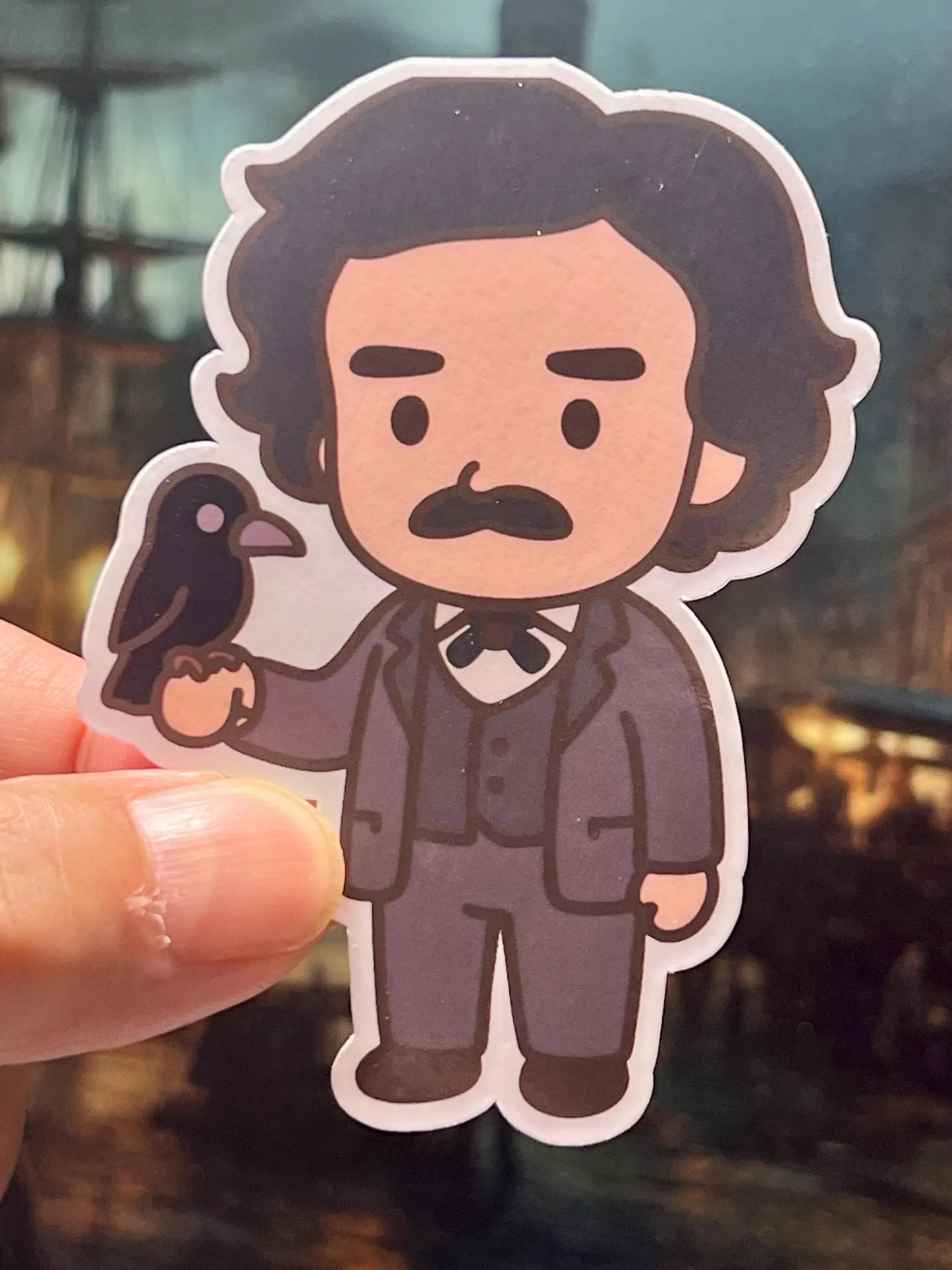Sticker of the author and poet Edgar Allen Poe. Poe is wearing a suit and carrying a raven.