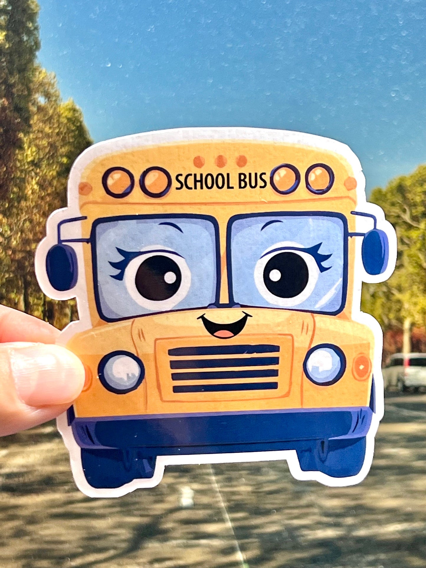 A sticker of a yellow school bus with a smiling face in a cute kawaii design