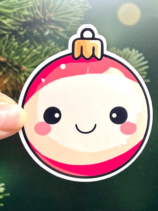 A round Christmas ornament sticker with a cute smiling face design.