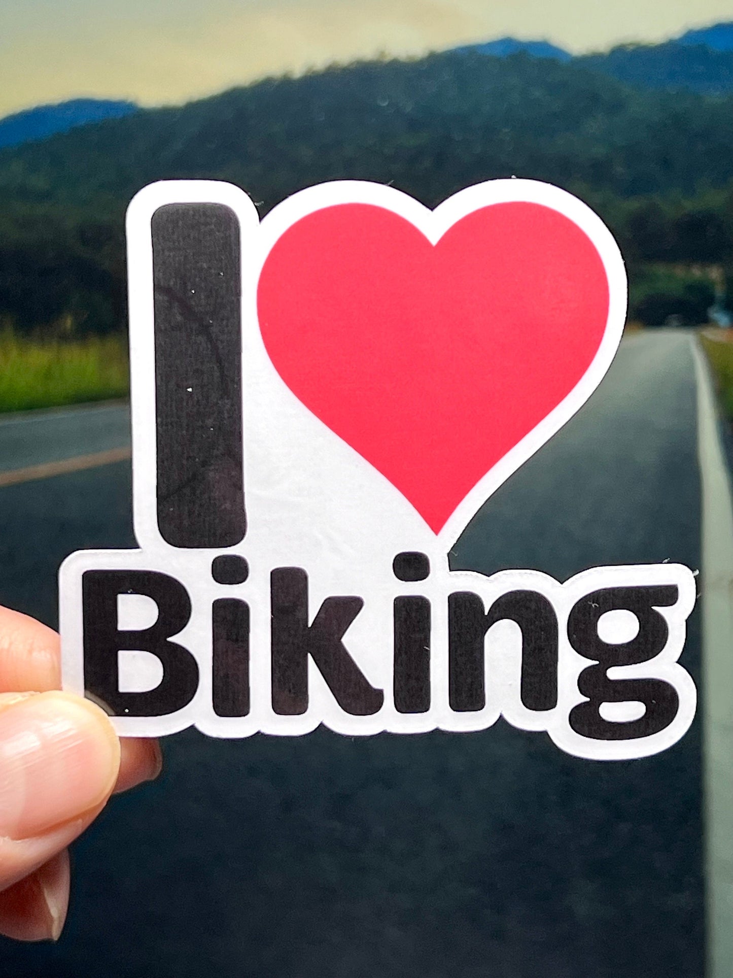 A vinyl sticker with the text 'I heart BIKING' and a red heart symbol