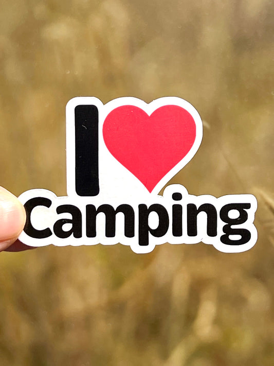 A vinyl sticker with the text 'I LOVE CAMPING' in red and black colors on a white background