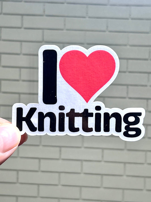 A vinyl sticker with the text 'I heart knitting' and a red heart symbol.