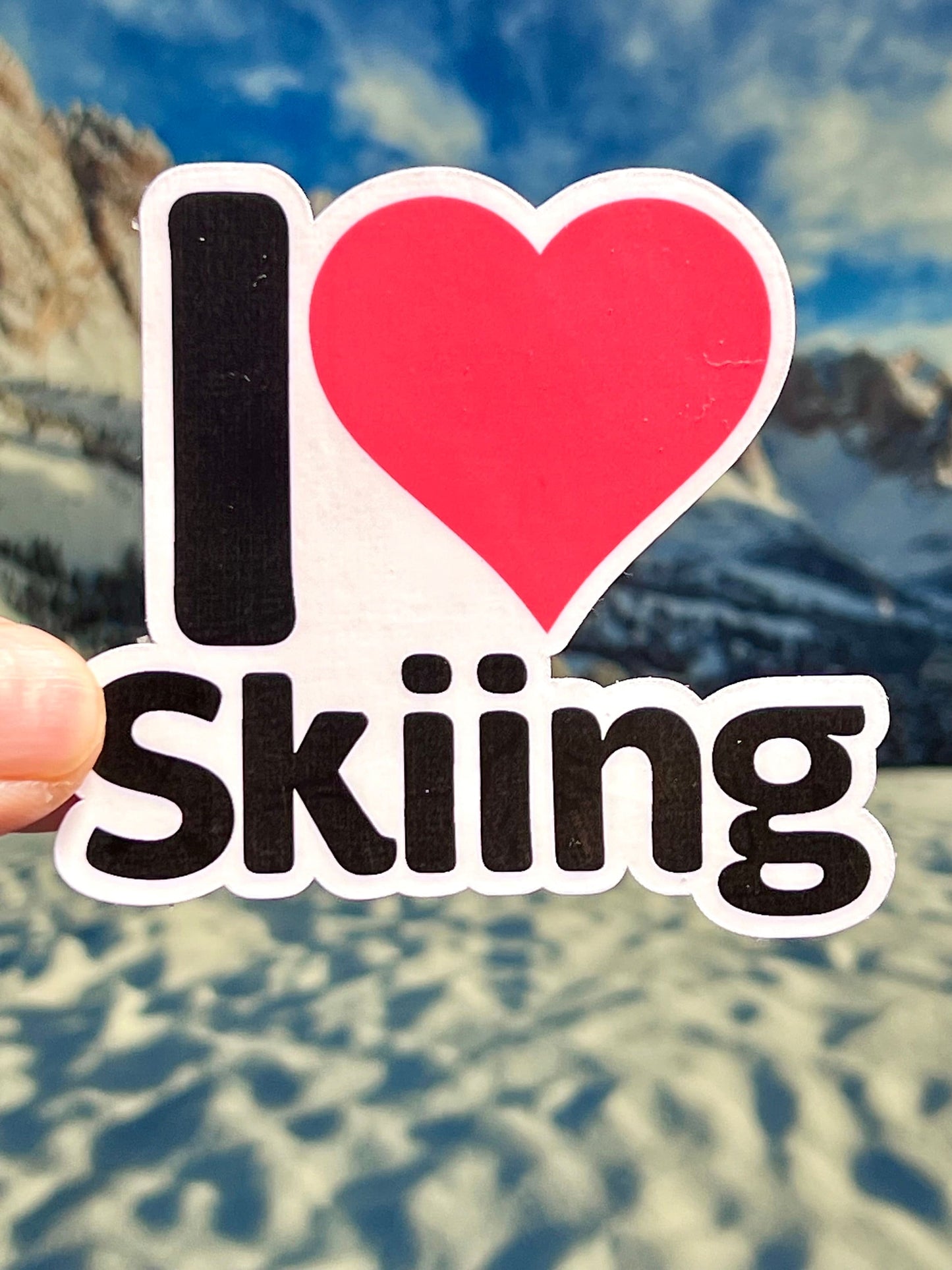 A vinyl sticker with the text 'I LOVE SKIING' and a red heart symbol replacing the word 'LOVE'.