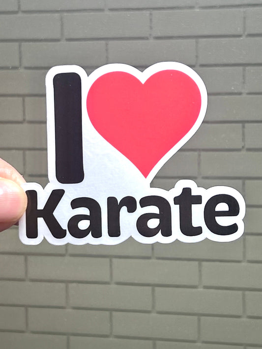 A vinyl sticker with the text 'I LOVE KARATE' and a heart symbol representing the word 'love'. The sticker is primarily black with red and white text.