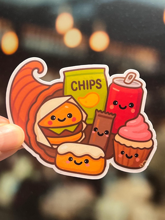 Sticker of a Thanksgiving Cornucopia draws in a kawaii cute style filled with junk food items including a hamburger, twinkie, chocolate bar, cupcake, chips, and soda pop. 