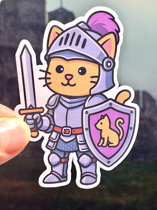 Sticker of a cat in knight armor holding a sword and shield with a paw print design.