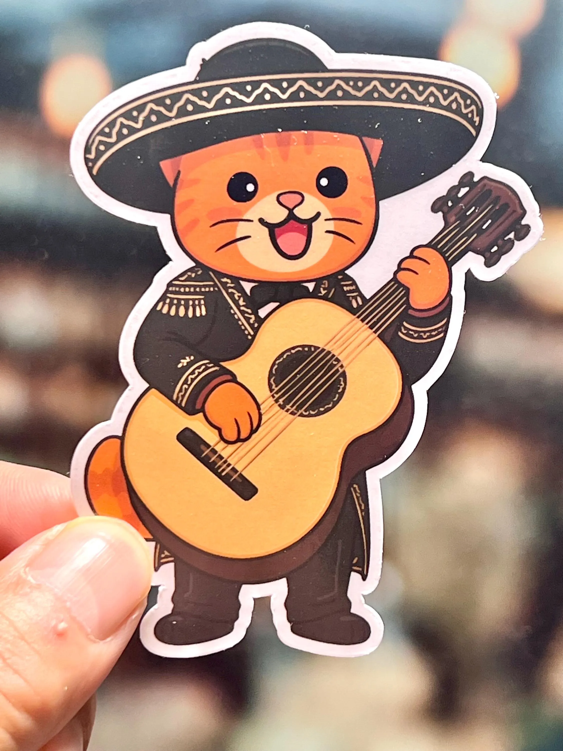 Sticker of a cat in mariachi attire holding a guitarron