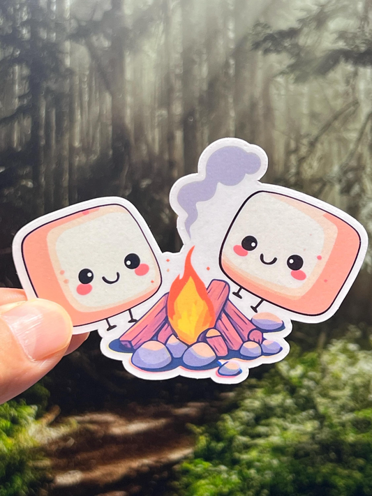 Sticker of cute marshmallows sitting around a campfire enjoying the warmth.