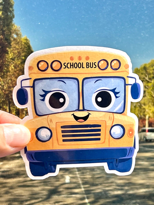 A sticker of a yellow school bus with a smiling face in a cute kawaii design