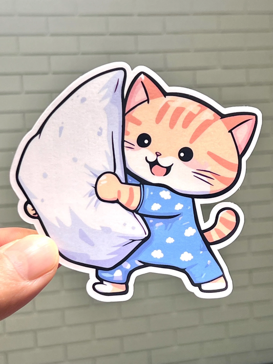 A sticker depicting a cartoon cat in pajamas holding a pillow getting ready for a pillow fight