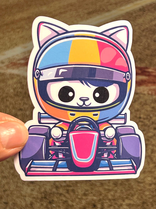 A colorful sticker of a cartoon-style cat wearing a race car driver suit and helmet, holding a steering wheel.