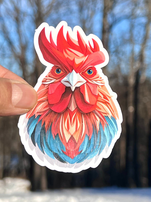 A colorful vinyl sticker of a rooster with a red comb and face, blue and green feathers