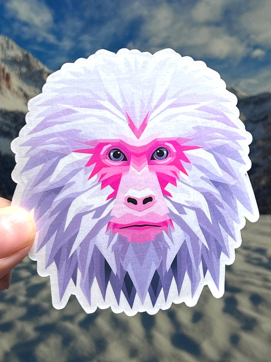 A vinyl sticker depicting the head of a Japanese Macaque, with pink and white fur, designed for use on water bottles and other surfaces.