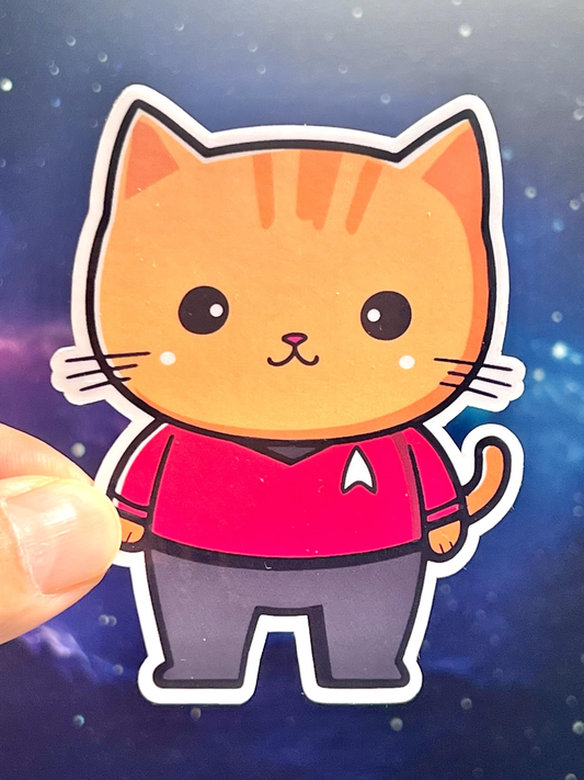 A sticker of a cartoon cat wearing a Star Trek red shirt, an engineering or security crew member