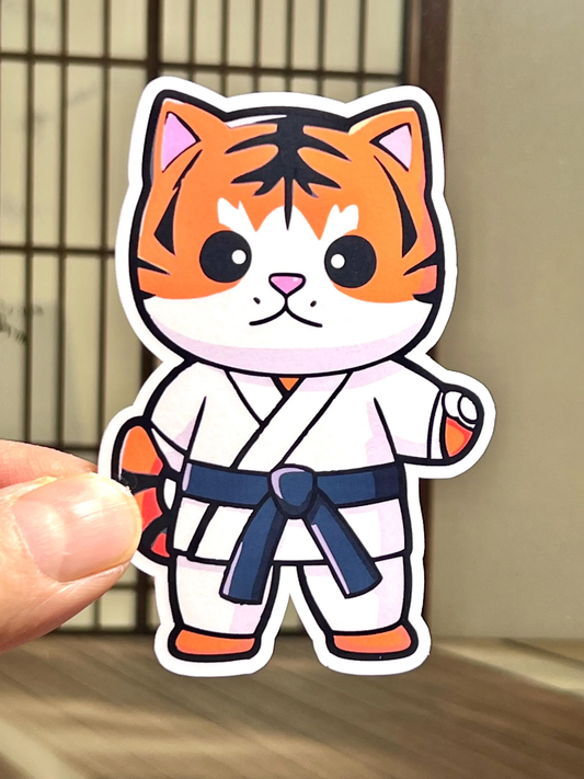 A sticker of a cartoon tiger wearing a karate gi.