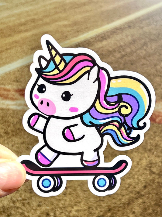 A colorful sticker of a skateboarding unicorn, with a vibrant pink mane and tail, and multicolored body and legs, riding a skateboard.