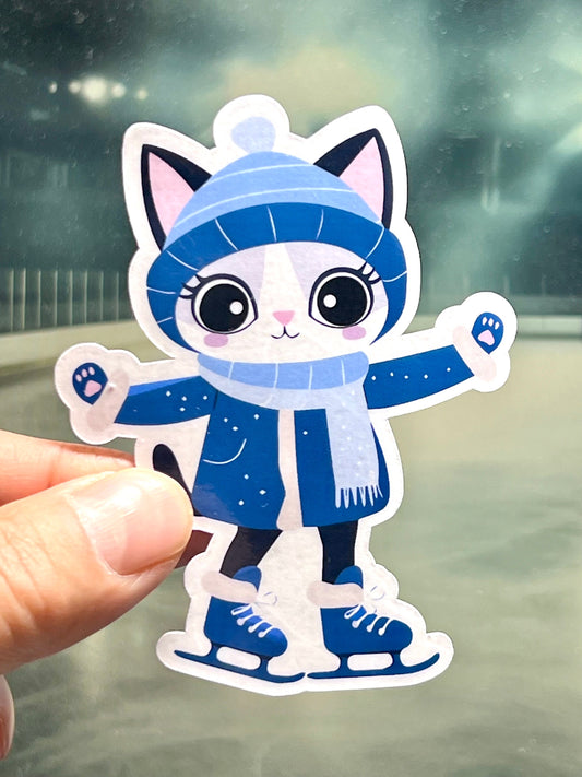 A sticker of a cute, cartoon-style cat wearing a winter skater outfit, including a blue coat and a snowflake hat, posed as if ice skating.